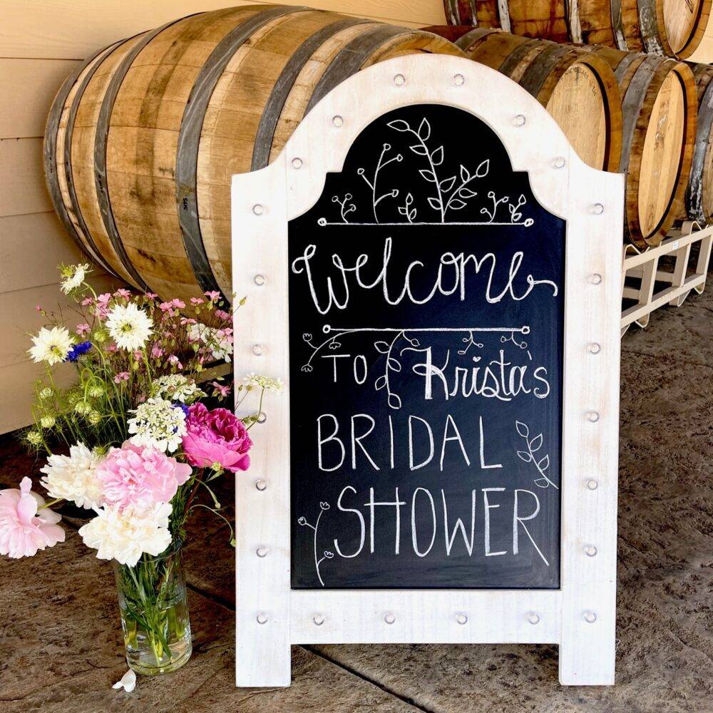 wine barrels and a sign for a bridal shower